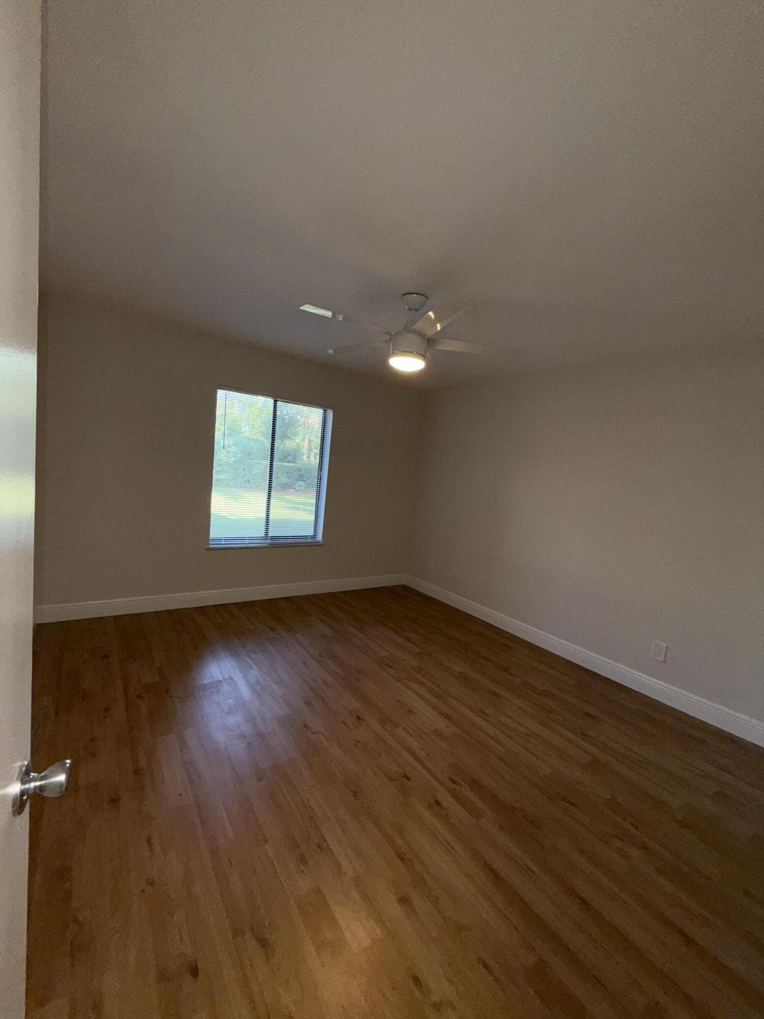 800 Northwest Fork Road, Unit 71 Stuart, FL 34994 - Photo 8 of 16 an empty room with wooden floor and windows