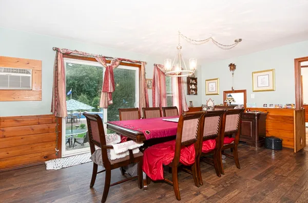 a dining room with furniture window and wooden floor
