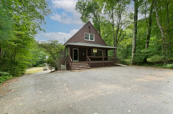 a view of a house with backyard and trees