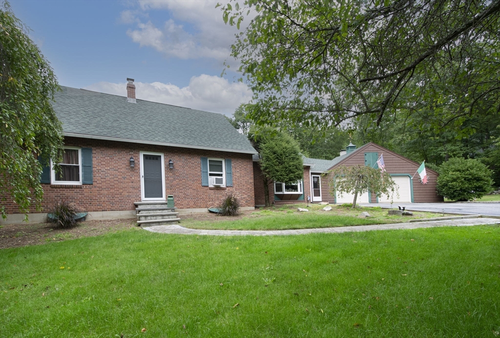 926 Old Turnpike Road Oakham, MA 01068 - Photo 5 of 42 a front view of a house with a garden and trees
