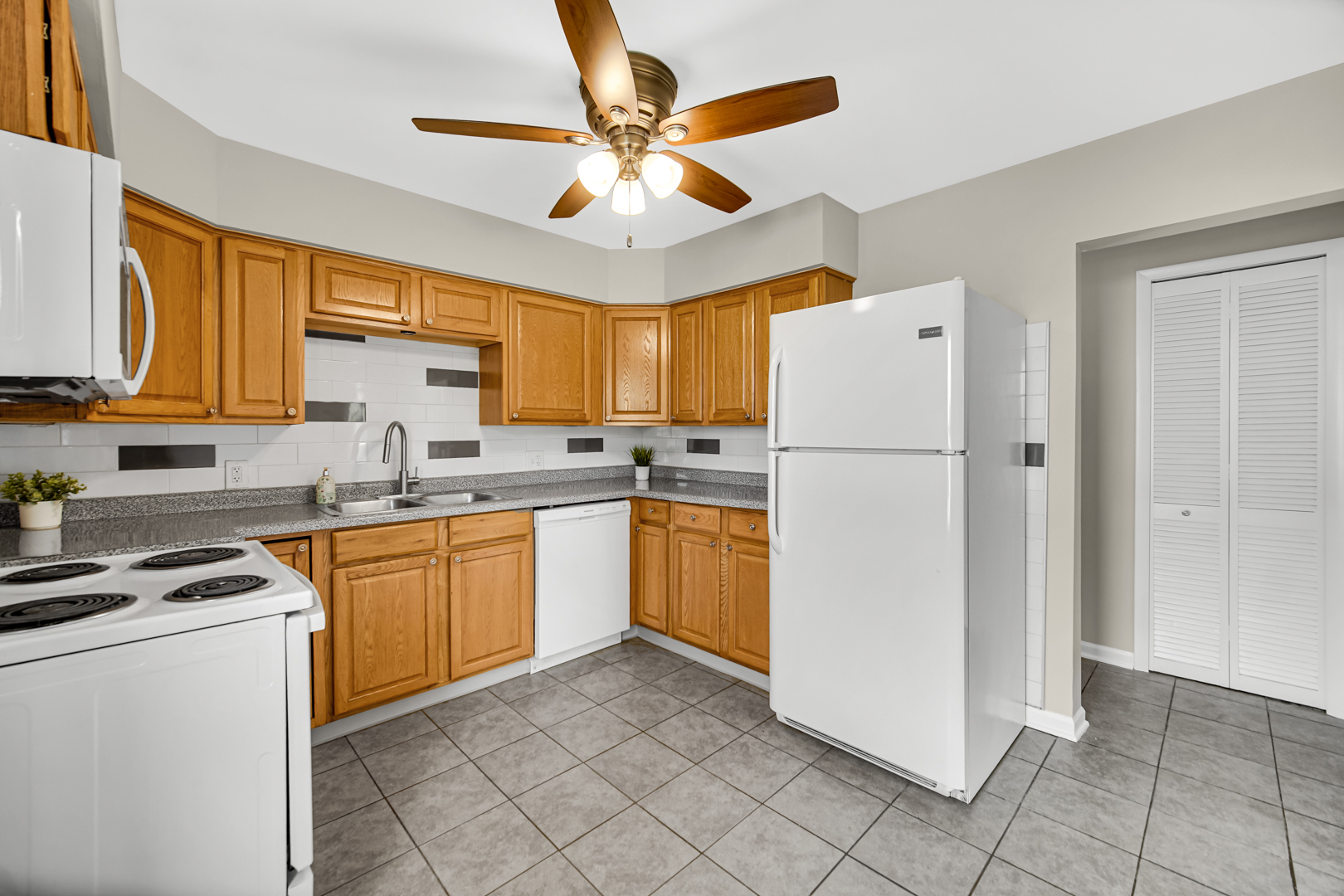 1455 Reckinger Road Aurora, IL 60505 - Photo 8 of 26 a kitchen with a refrigerator a stove top oven cabinets and a window