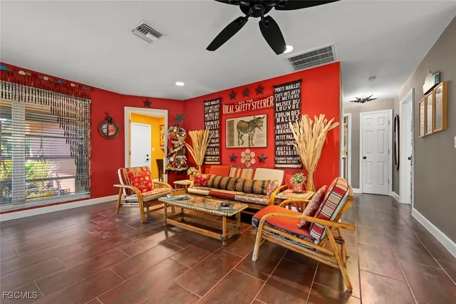 a living room with furniture a ceiling fan and a rug