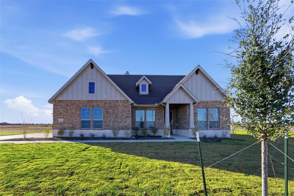 1030 County Road 200 Valley View, TX 76272 - Photo 2 of 27 View of front facade with board and batten siding, a front yard, and brick siding