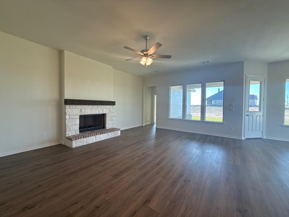 1030 County Road 200 Valley View, TX 76272 - Photo 3 of 8 a view of an empty room with wooden floor fireplace and a window