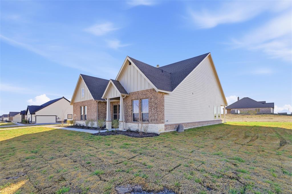 1030 County Road 200 Valley View, TX 76272 - Photo 4 of 27 View of front of home featuring board and batten siding, a front yard, and brick siding