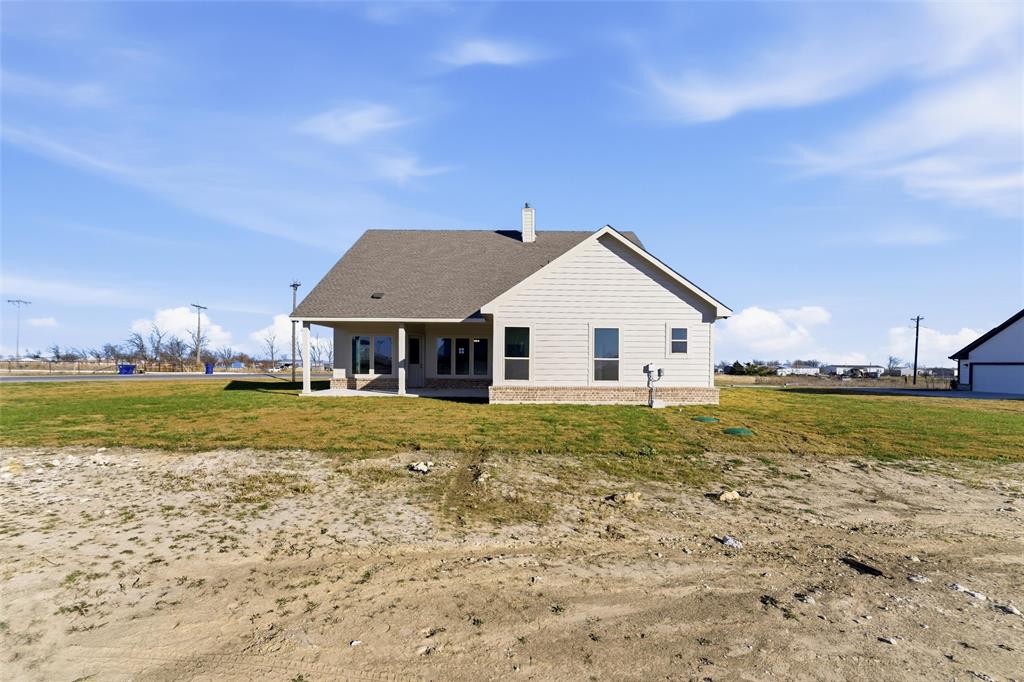 1030 County Road 200 Valley View, TX 76272 - Photo 5 of 27 Back of house featuring a patio, a chimney, a yard, and a shingled roof