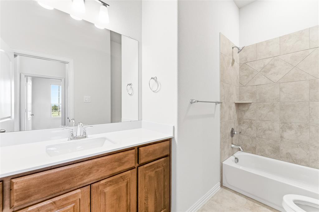 1030 County Road 200 Valley View, TX 76272 - Photo 10 of 27 Bathroom with washtub / shower combination, vanity, and light tile patterned flooring