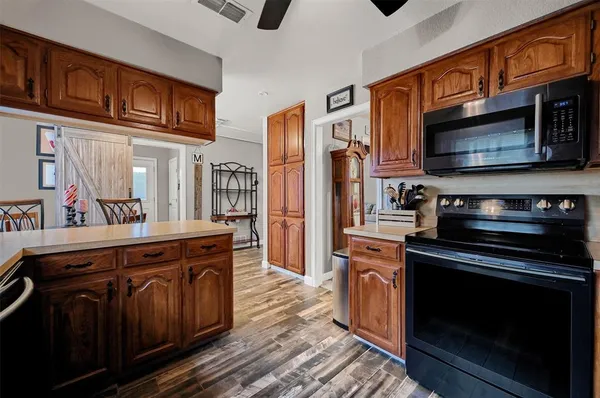 a kitchen with stainless steel appliances granite countertop a stove microwave and cabinets
