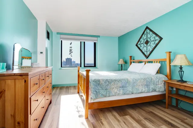 a bedroom with a bed window and dresser