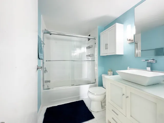 a bathroom with a sink a toilet a shower and a mirror