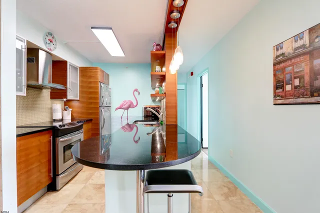 a view of kitchen island with stainless steel appliances granite countertop sink stove and refrigerator