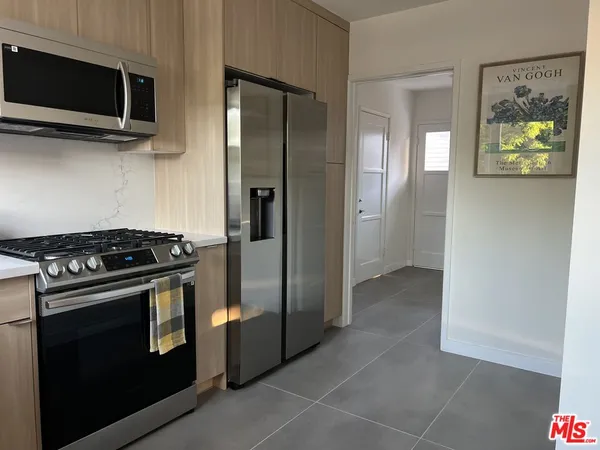 a kitchen with stainless steel appliances granite countertop a stove and a microwave