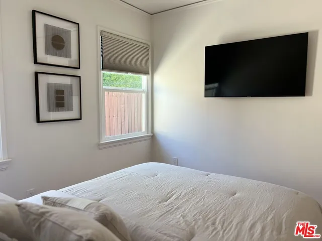 a bedroom with a bed and a flat screen tv