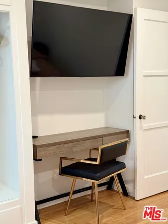 a view of a hallway with wooden floor and furniture
