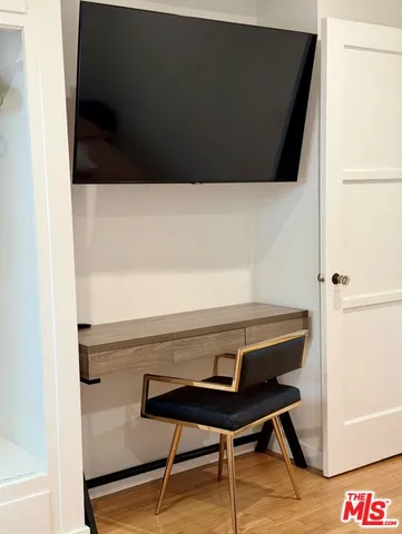 a view of a hallway with wooden floor and furniture