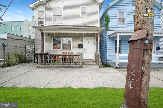 a view of a house with brick walls and a yard with plants
