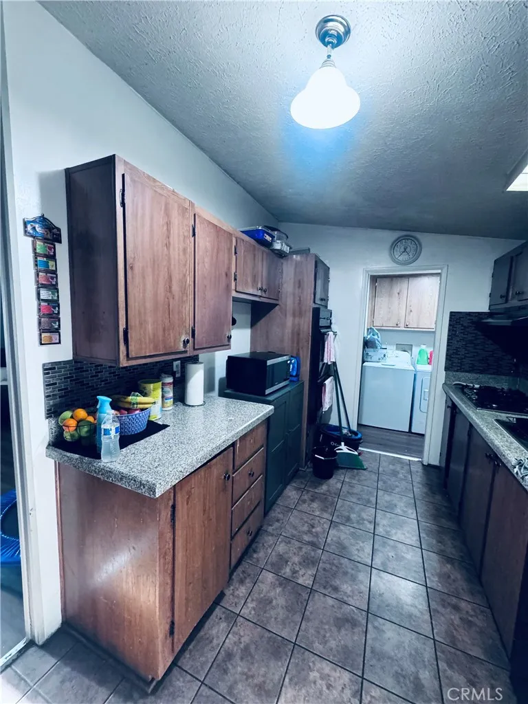 250 North Linden Avenue, Unit 250 Rialto, CA 92376 - Photo 12 of 29 a kitchen with granite countertop a stove a sink and a refrigerator