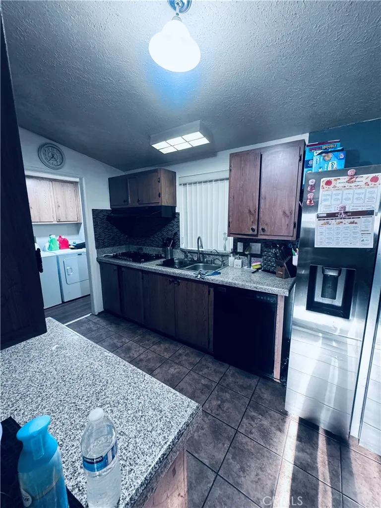 250 North Linden Avenue, Unit 250 Rialto, CA 92376 - Photo 14 of 29 a kitchen with stainless steel appliances granite countertop a sink stove and refrigerator