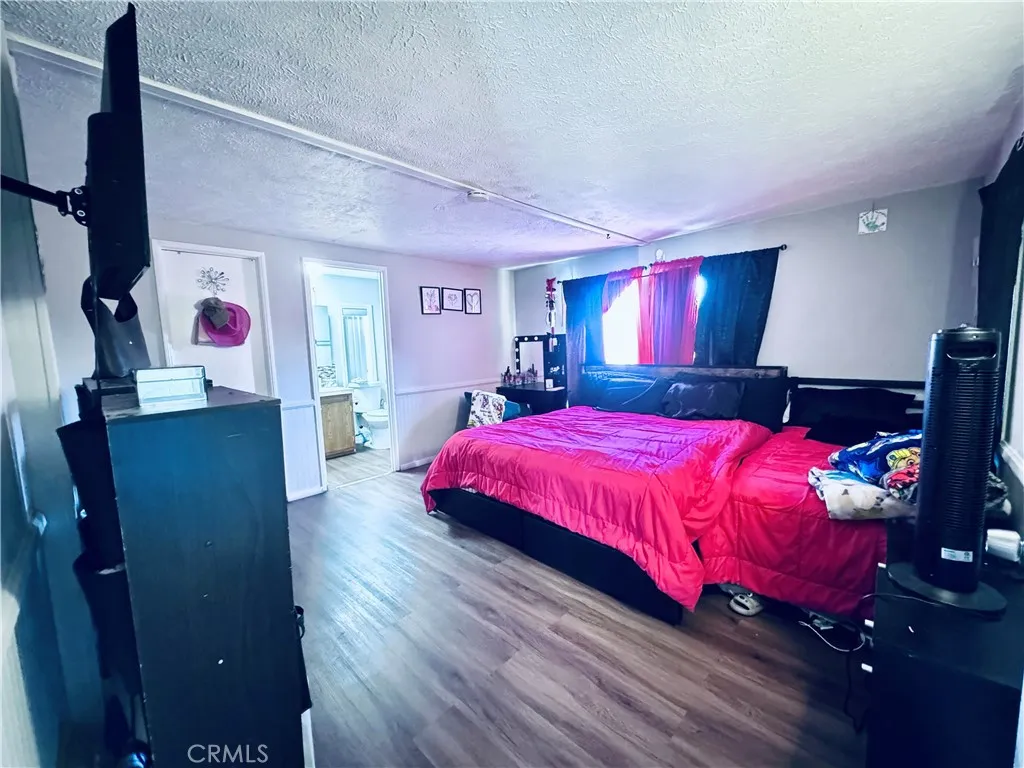 250 North Linden Avenue, Unit 250 Rialto, CA 92376 - Photo 21 of 29 a spacious bedroom with a bed and wooden floor