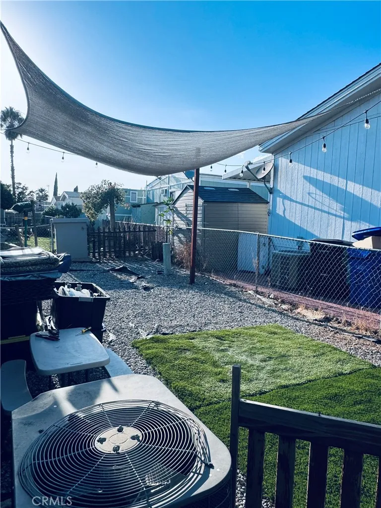 250 North Linden Avenue, Unit 250 Rialto, CA 92376 - Photo 28 of 29 a patio with table and chairs with wooden floor and fence