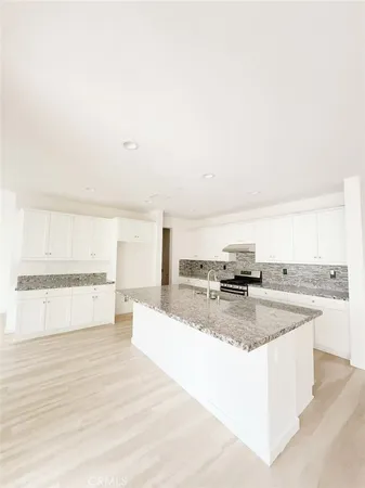 a large kitchen with stainless steel appliances granite countertop a stove and a sink