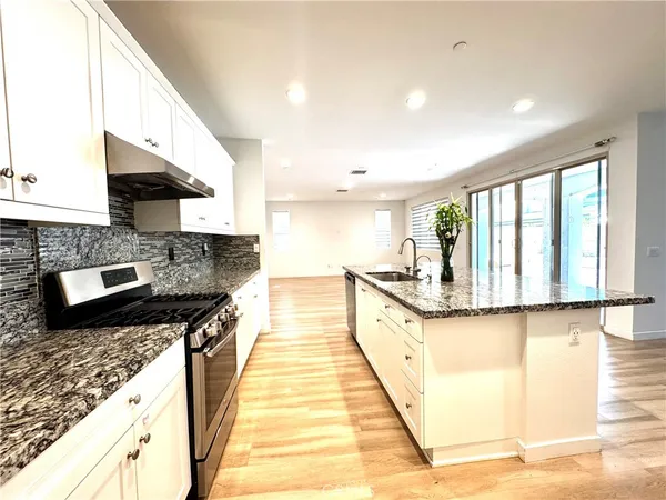 a kitchen with granite countertop a sink and cabinets
