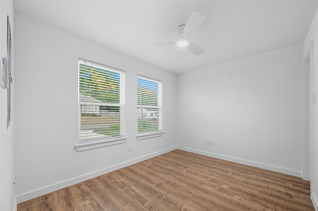 1315 Oneal Street, Unit B Commerce, TX 75428 - Photo 5 of 14 an empty room with wooden floor and windows