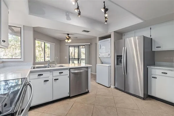 a large white kitchen with a refrigerator a sink dishwasher a stove and a refrigerator
