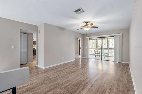 a view of an empty room with a window and wooden floor