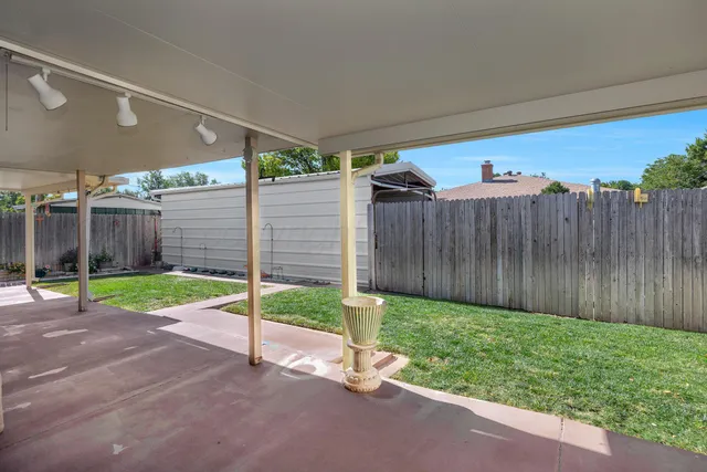 a view of a backyard with wooden fence