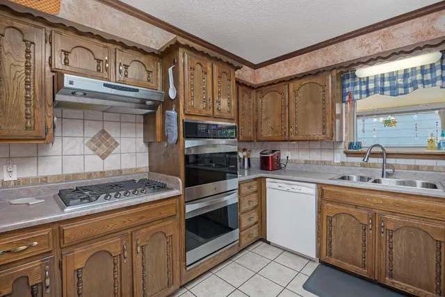 a kitchen with stainless steel appliances granite countertop a stove and a sink