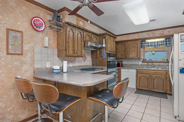 a kitchen with granite countertop a sink cabinets and stove