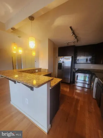 a kitchen with stainless steel appliances granite countertop a sink and a stove