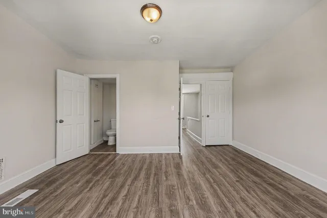 a view of a hallway with wooden floor and entryway