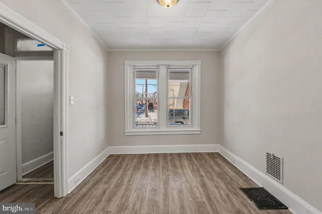 a view of a hallway with wooden floor and entryway