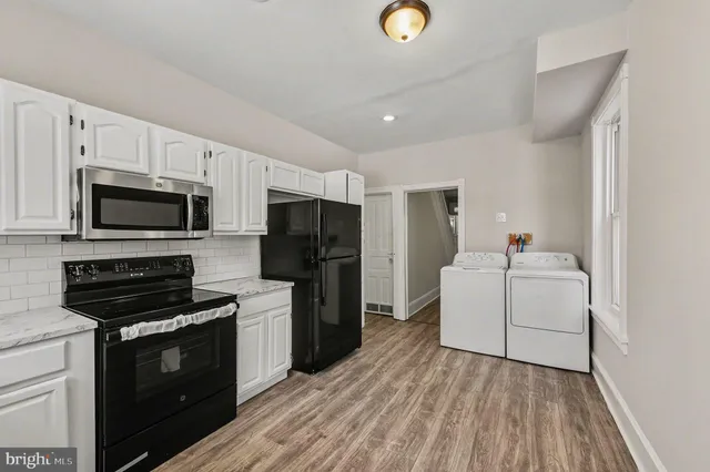a kitchen with white cabinets and stainless steel appliances