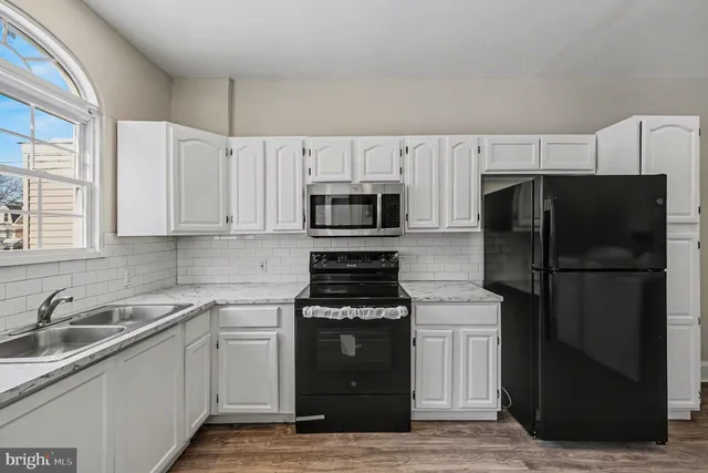 a kitchen with a refrigerator and a stove top oven