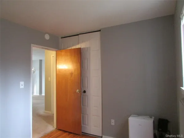 a view of a small space with wooden floor and a window