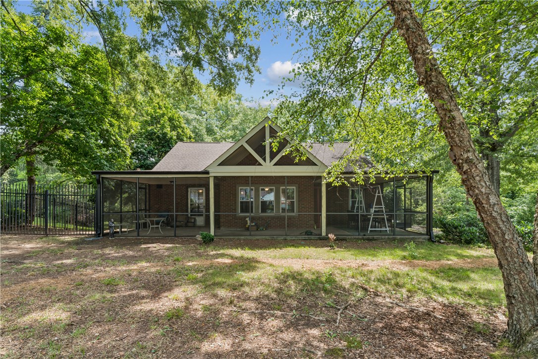 321 South Pine Street Walhalla, SC 29691 - Photo 1 of 32 A spacious screened-in porch creates a peaceful outdoor retreat, overlooking a large, tree-lined yard.