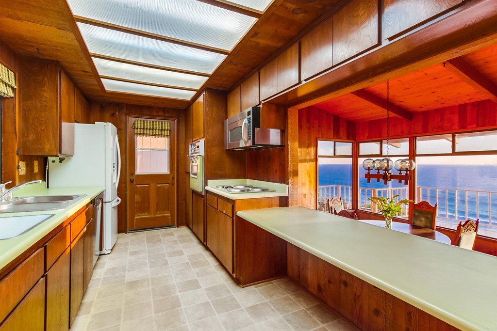 1236 Neptune Avenue Encinitas, CA 92024 - Photo 13 of 40 a large kitchen with stainless steel appliances granite countertop a stove and a dining table