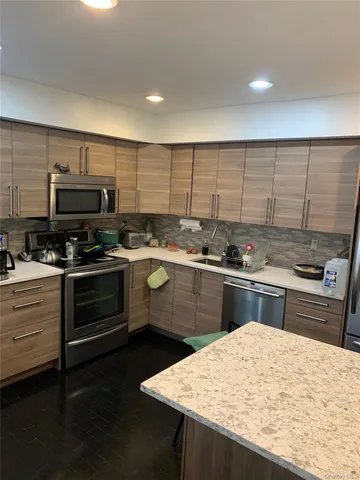 a kitchen with kitchen island a sink stainless steel appliances and cabinets