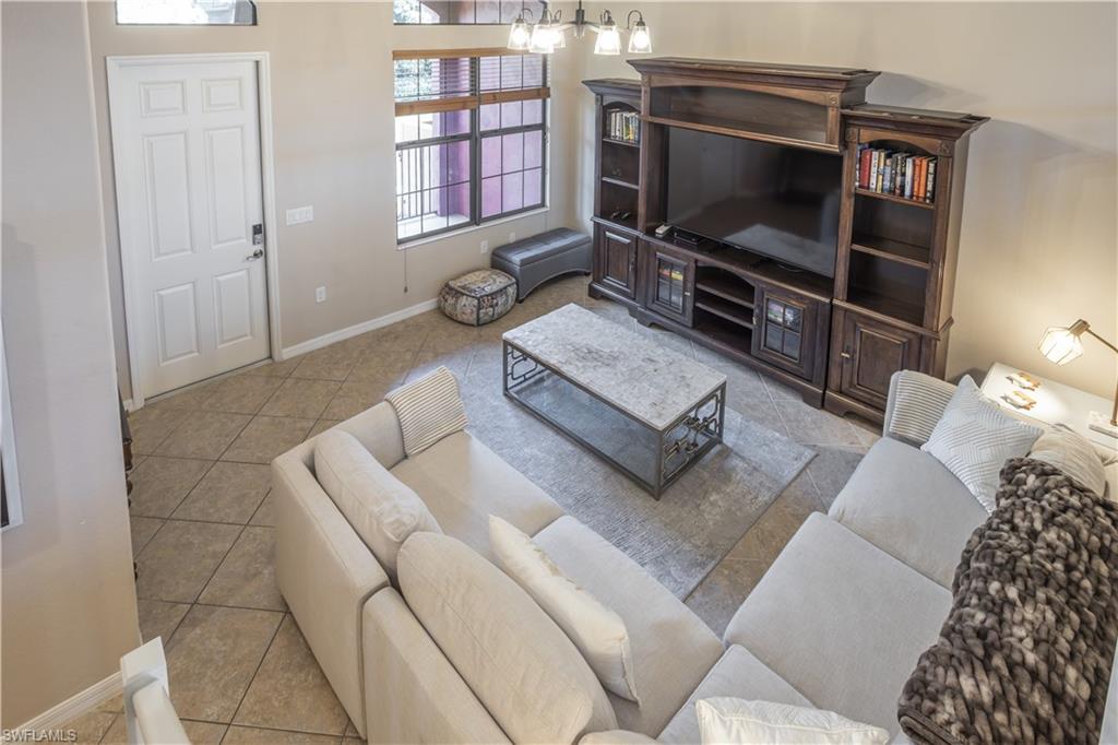 9063 Capistrano Street North, Unit 4408 Naples, FL 34113 - Photo 11 of 50 a living room with furniture and a flat screen tv