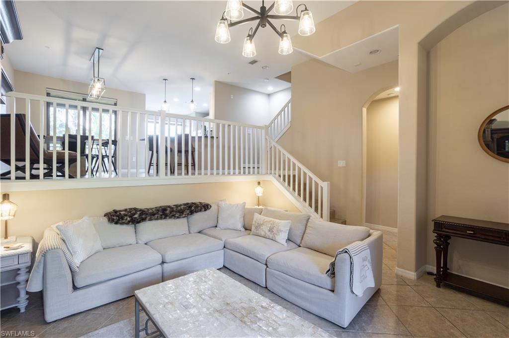 9063 Capistrano Street North, Unit 4408 Naples, FL 34113 - Photo 12 of 50 a living room with furniture and a chandelier