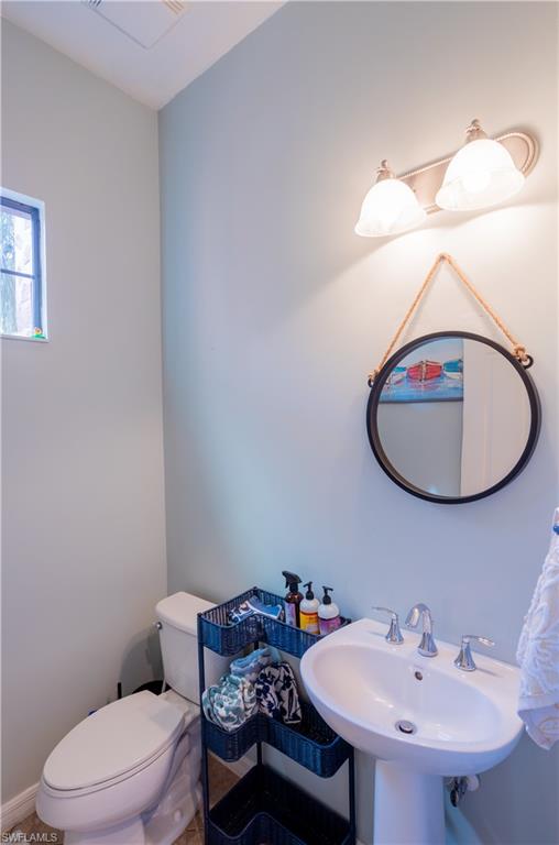 9063 Capistrano Street North, Unit 4408 Naples, FL 34113 - Photo 17 of 50 a bathroom with a sink a toilet and a mirror