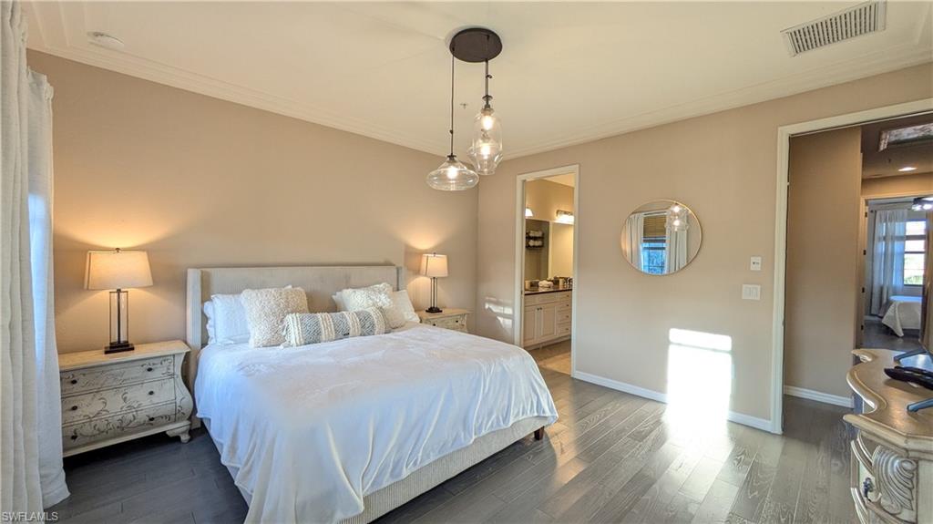 9063 Capistrano Street North, Unit 4408 Naples, FL 34113 - Photo 19 of 50 a bedroom with a bed and a chandelier