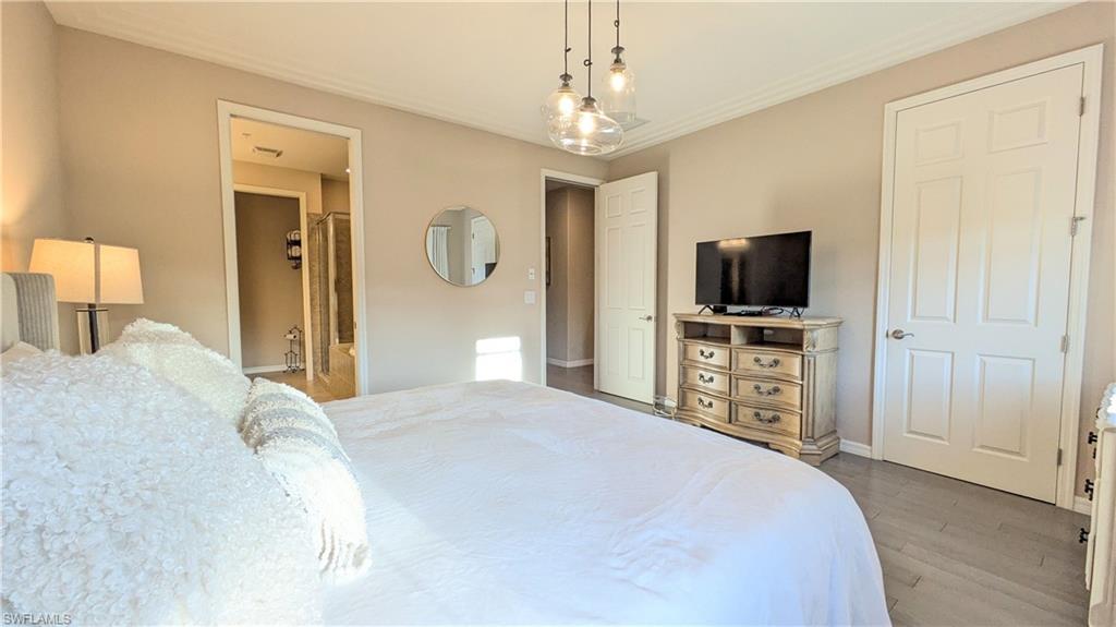 9063 Capistrano Street North, Unit 4408 Naples, FL 34113 - Photo 20 of 50 a spacious bedroom with a bed and a flat screen tv
