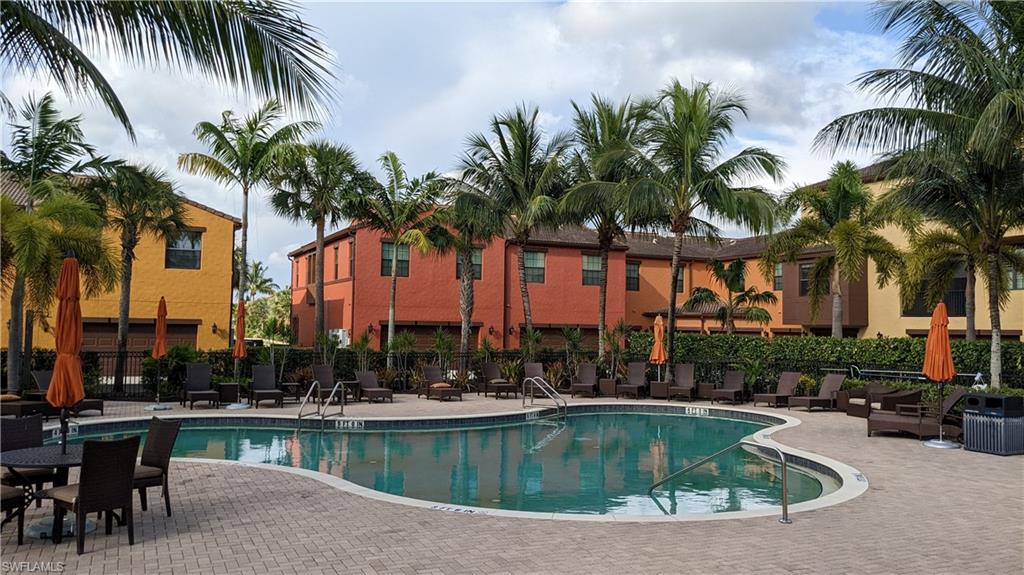 9063 Capistrano Street North, Unit 4408 Naples, FL 34113 - Photo 30 of 50 a view of swimming pool with outdoor seating and palm trees