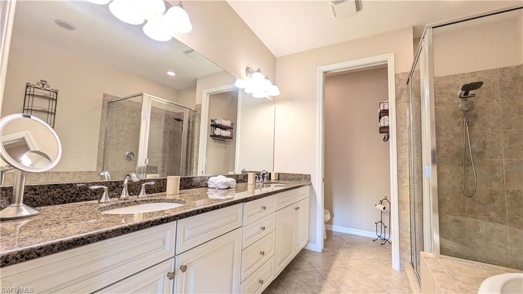 9063 Capistrano Street North, Unit 4408 Naples, FL 34113 - Photo 6 of 50 a bathroom with a double vanity sink mirror and shower