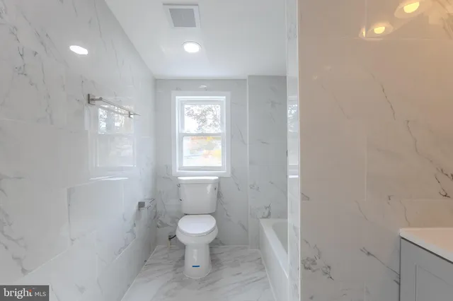 a white toilet sitting next to a bathroom sink and vanity