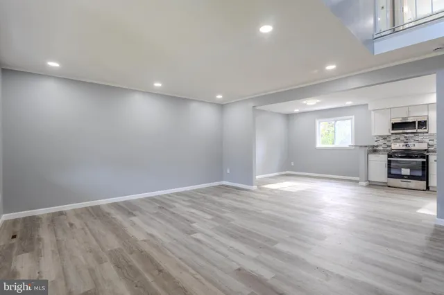 a view of empty room with wooden floor and fireplace